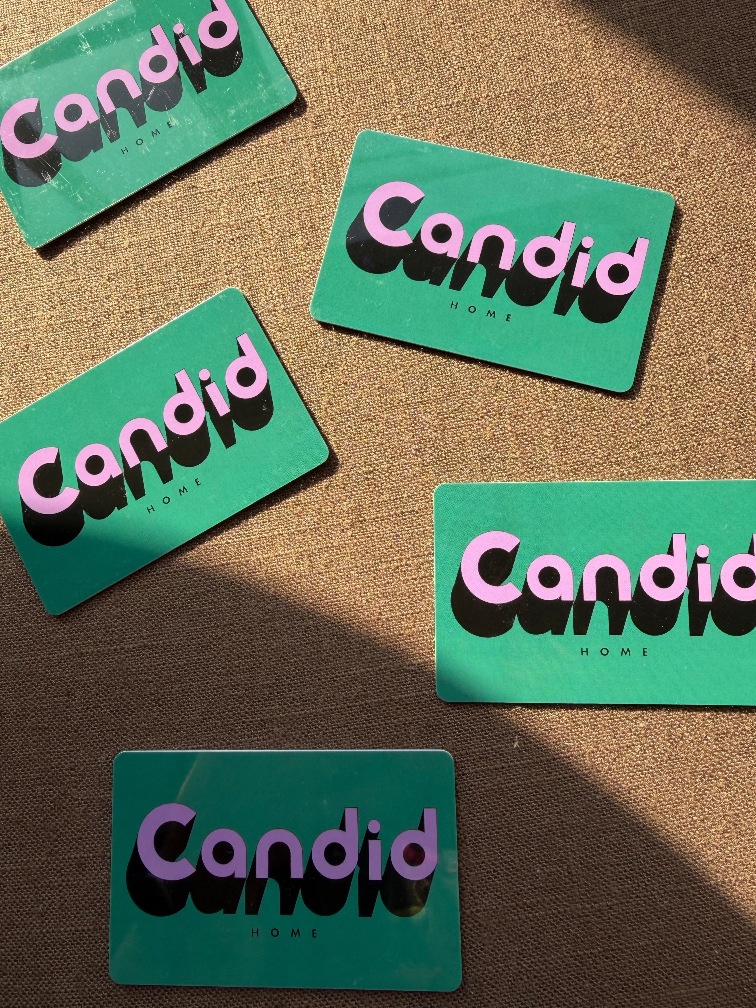 Green gift cards with 'Candid' text on a brown textured background